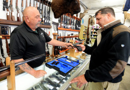 Bill Karnok, left, of Grandpa's Pawn Shop in Longmont, Colo., shows Brian Hirak, a private investigator from API of Colorado, a gun that he is interested in buying on Tuesday, Jan. 5, 2016. President Barack Obama unveiled his plan Tuesday to tighten control and enforcement of firearms in the U.S.   (Cliff Grassmick/Daily Camera via AP) NO SALES; MANDATORY CREDIT