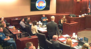 In this image taken from video, Ashley Moser, top right, whose daughter Veronica Moser-Sullivan, 6, was killed by James Holmes, who sits fifth from left in a gray shirt, testifies during the penalty phase of Holmes' trial in Centennial, Colo., Wednesday, Aug. 5, 2015. Prosecutor George Brauchler, center, questions Moser. (Colorado Judicial Department via AP, Pool)